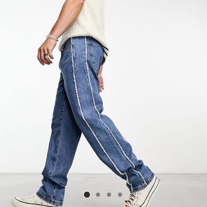 straight leg jeans with fraying side seams in mid wash blue